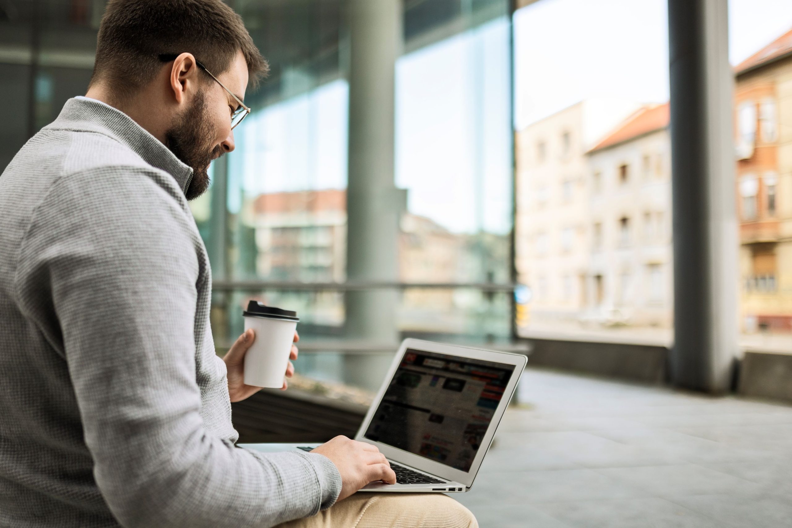 man seated outside on laptop